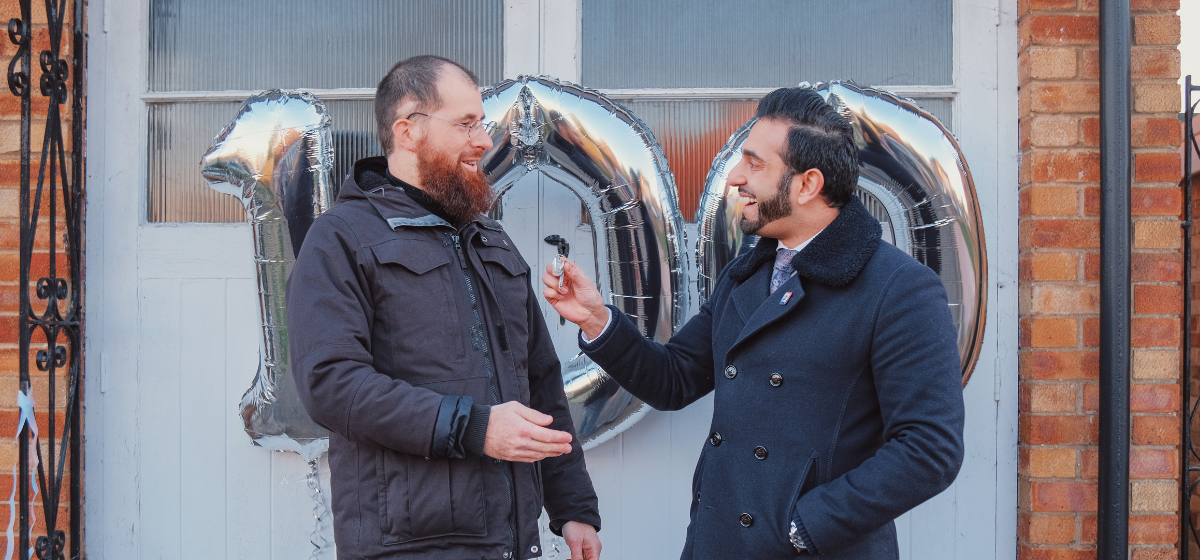 Raza Ullah handing Pfida customer Dimitri’s keys to his new home